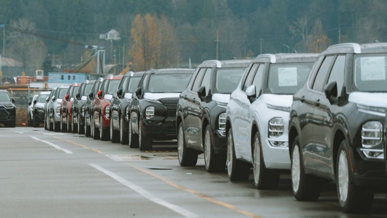 A line of new SUVs parked in an outdoor dealership lot, ready for sale.