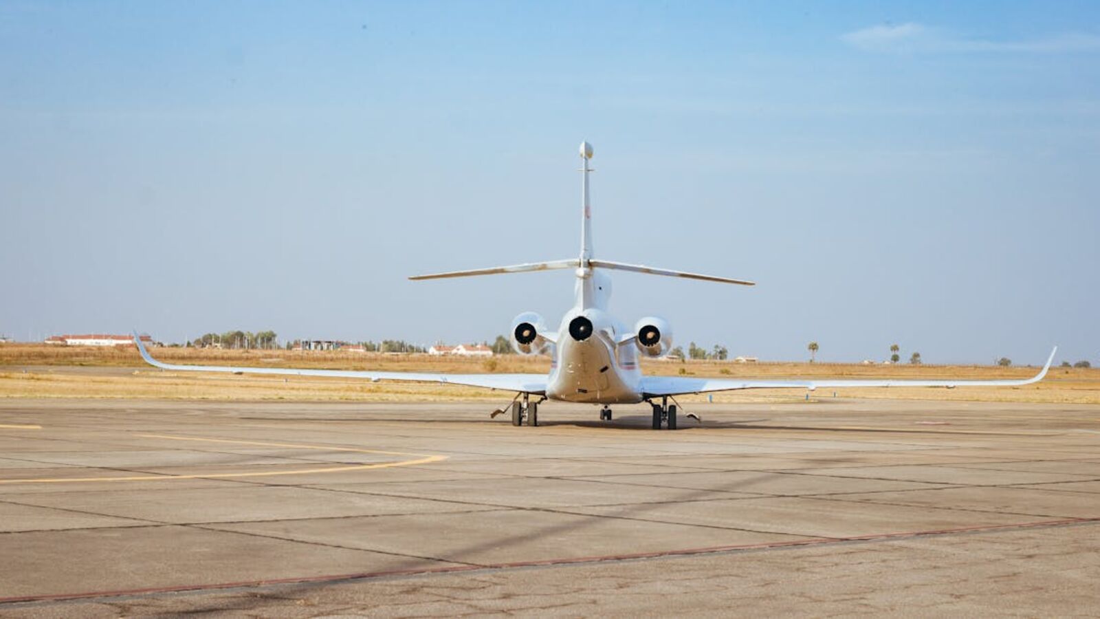 A private jet parked on an airport runway in Jos, Nigeria, under clear skies.