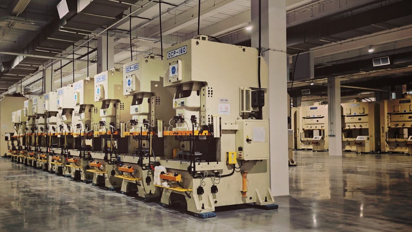 Выкуп оборудования в Санкт-Петербурге — A row of industrial machines on a factory floor, highlighting manufacturing equipment.