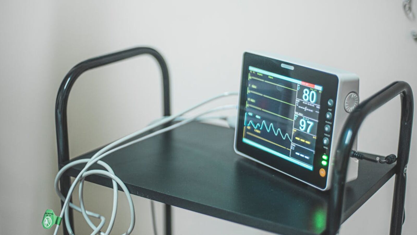 Medical equipment showing heart rate on screen in hospital room.