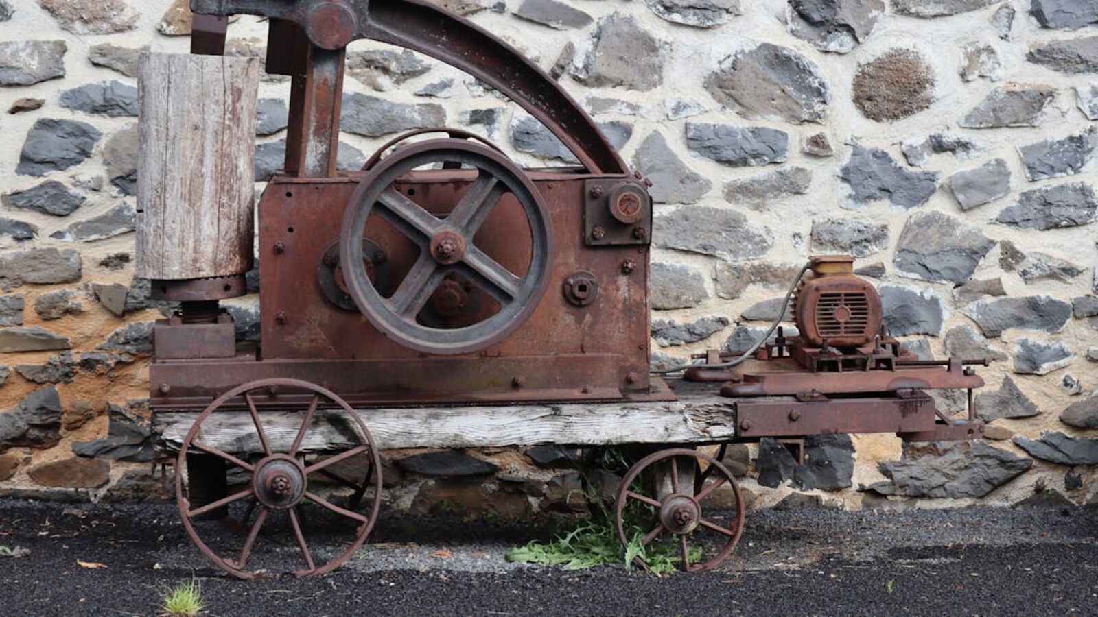 Rusted vintage machinery with stone wall background, perfect for industrial themes.