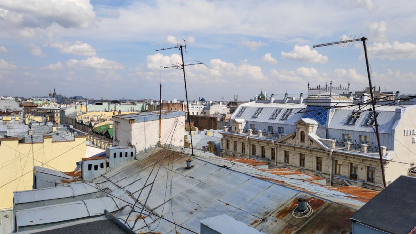 Aerial view of historic rooftops and skyline in Saint Petersburg, showcasing urban architecture and vibrant city landscape.