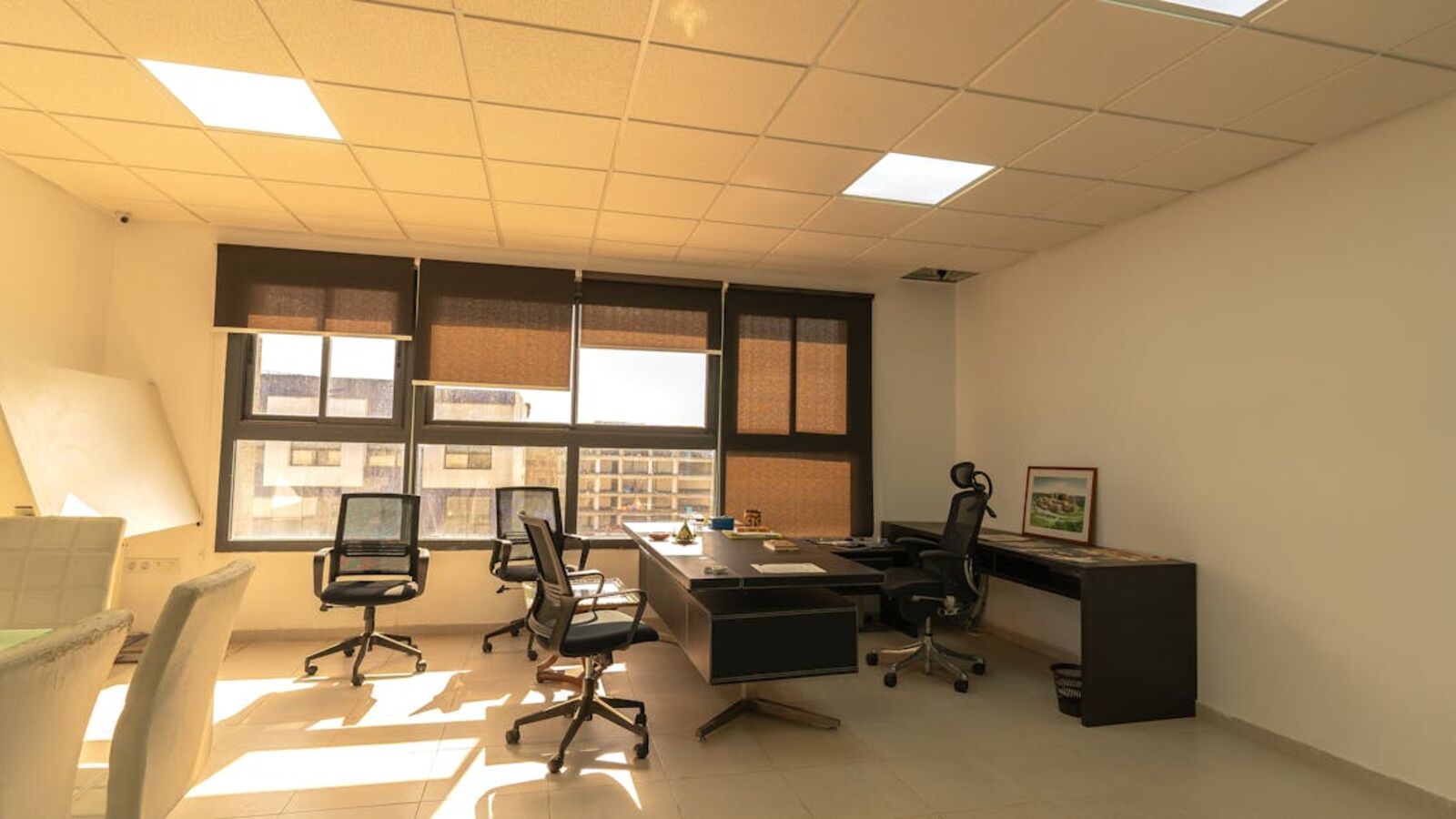Bright and spacious office interior with natural lighting, featuring desks and chairs.