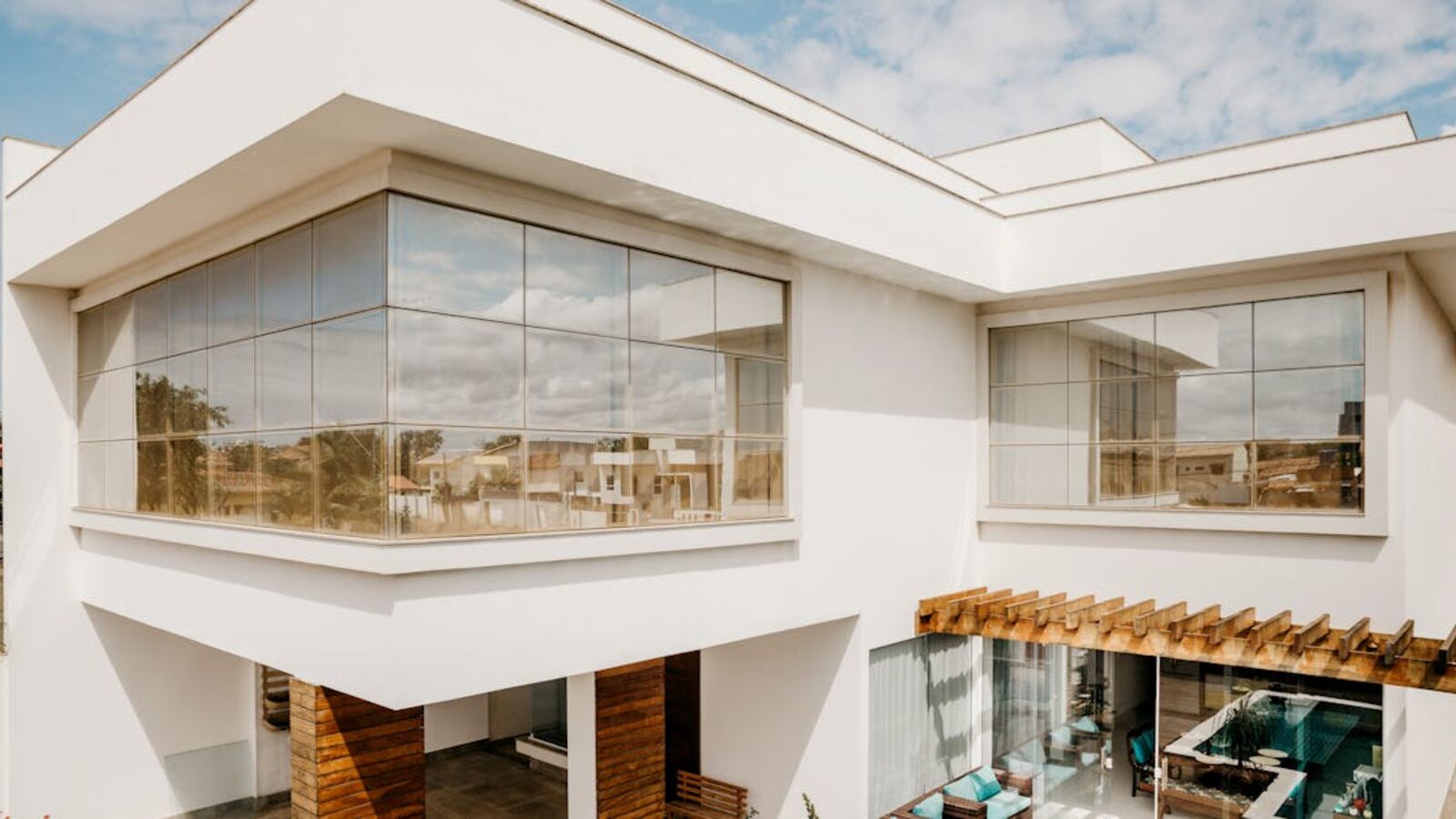 Выкуп домов в Санкт-Петербурге и Ленинградской области — Exterior of contemporary cottage with large windows and stylish terrace against cloudy blue sky
