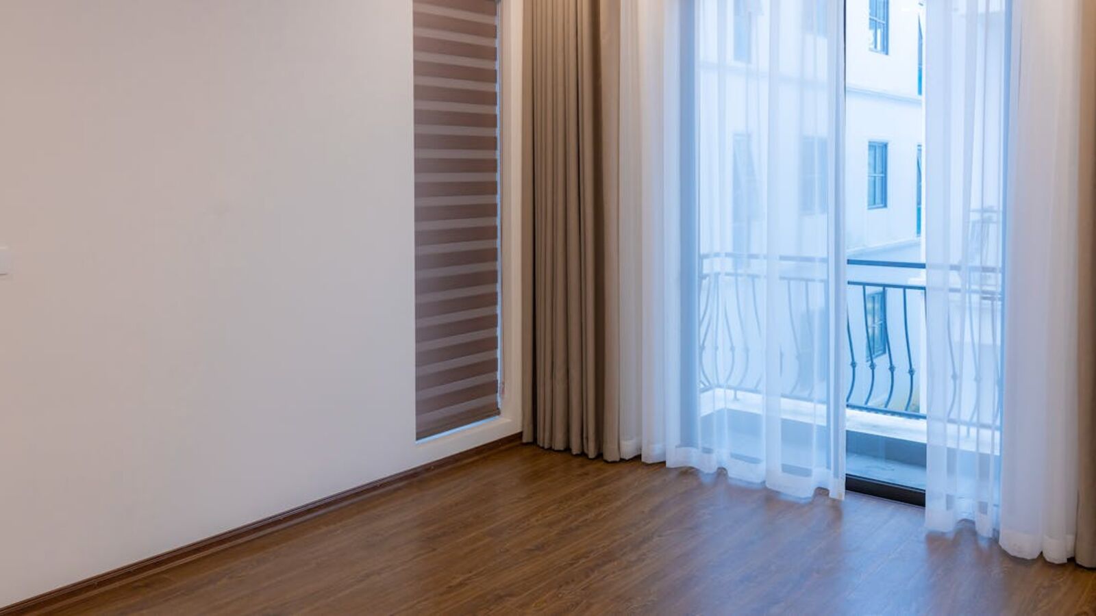 Bright modern room with wooden floor and large windows, ideal for real estate or interior design inspiration.