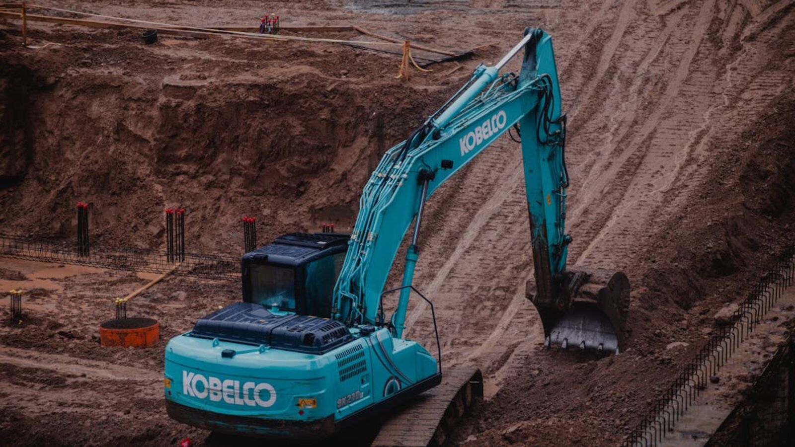 Выкуп асфальтоукладчиков в Санкт-Петербурге — Blue excavator digging a pit at a construction site in Vilnius, Lithuania.